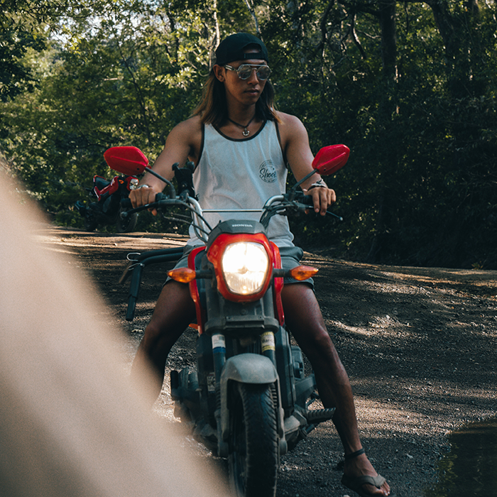 Ohana Rental Tamarindo Founder Samuel riding on a Honda Navi Scooter on a dirt road at the Tamarindo Estuary